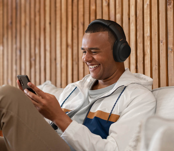 Person using Sony WH-1000XM4 noise cancelling headset and laughing.